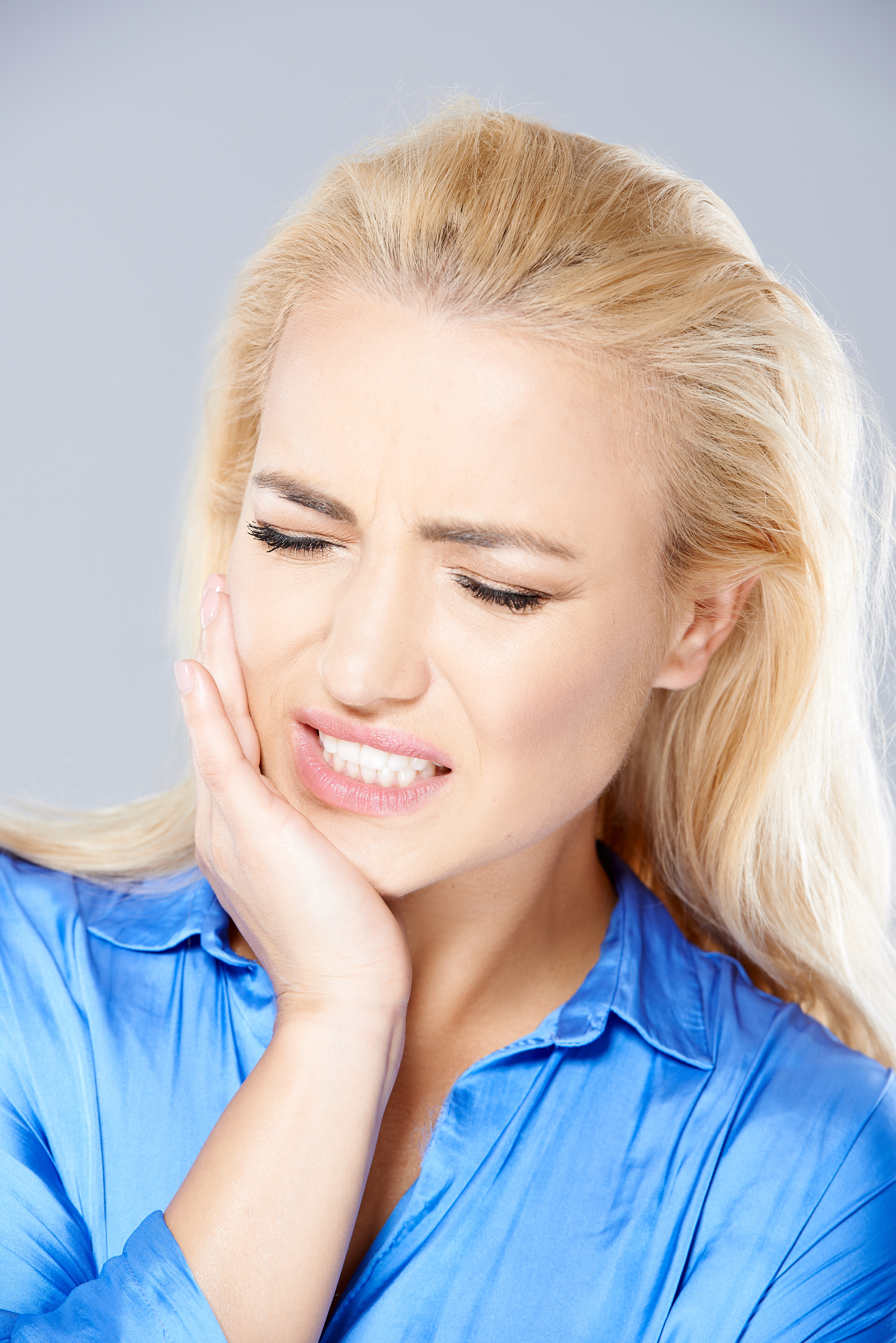 blond woman suffering from teeth grinding or bruxism